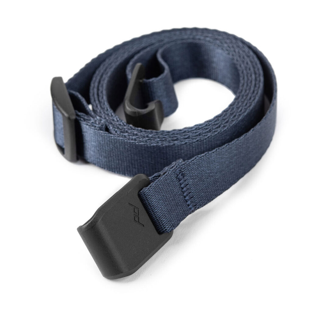 Peak-Design-Field-Pouch-V2-midnight-7 Peak Design Field Pouch V2 - Midnight -laukussa on kääritty laivastonsininen hihna, jonka molemmissa päissä on mustat muoviklipsit, jotka sopivat täydellisesti tavaroiden kiinnittämiseen.