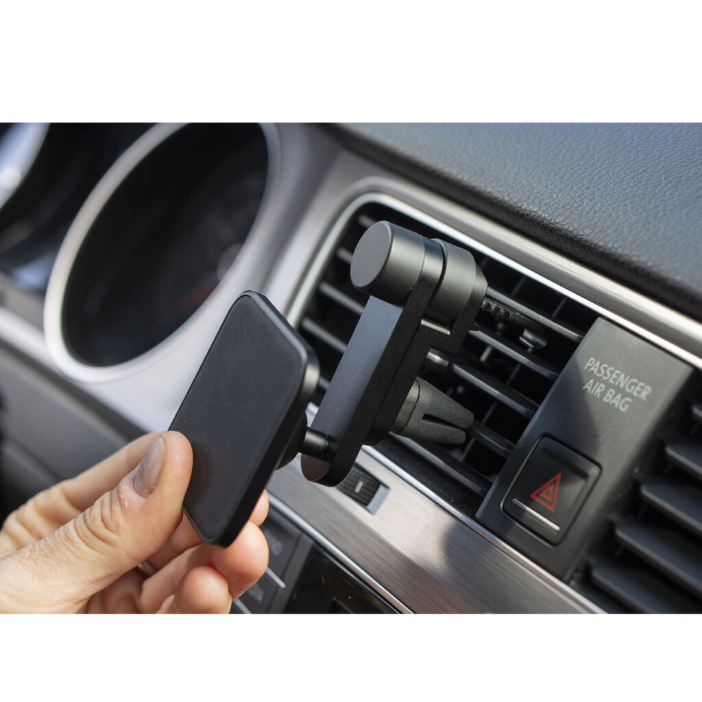 Peak-Design-Mobile-Car-Mount-Vent-4 Käsi kiinnittää Peak Design Mobile Car Mount Ventin, mustan magneettipuhelimen pidikkeen, auton kojelaudan tuuletusaukkoon matkustajan turvatyynyn ja hätävilkun painikkeiden lähelle.