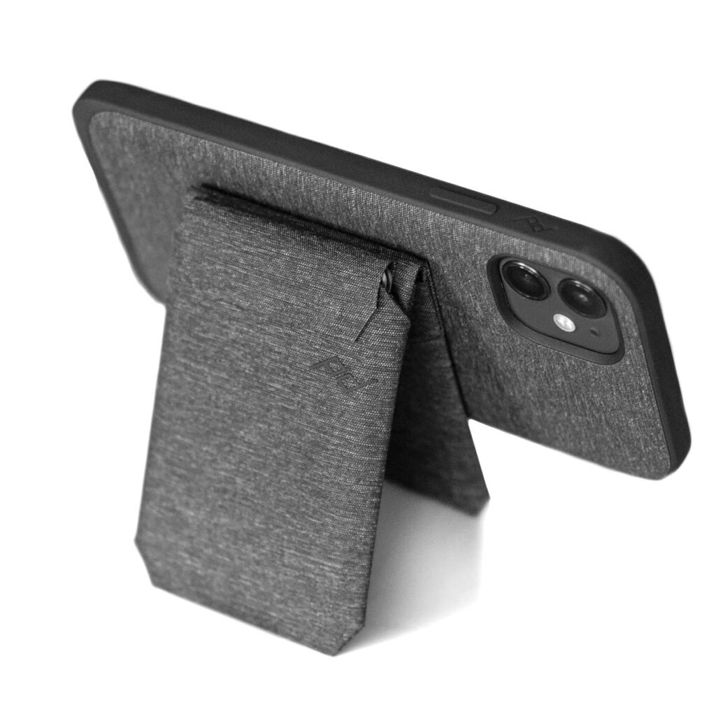 Peak-Design-Mobile-Stand-Wallet-4 Kaksoiskameralla varustettu älypuhelin tuetaan Peak Design Mobile Wallet Stand - Charcoal -malliin takaa valkoista taustaa vasten.