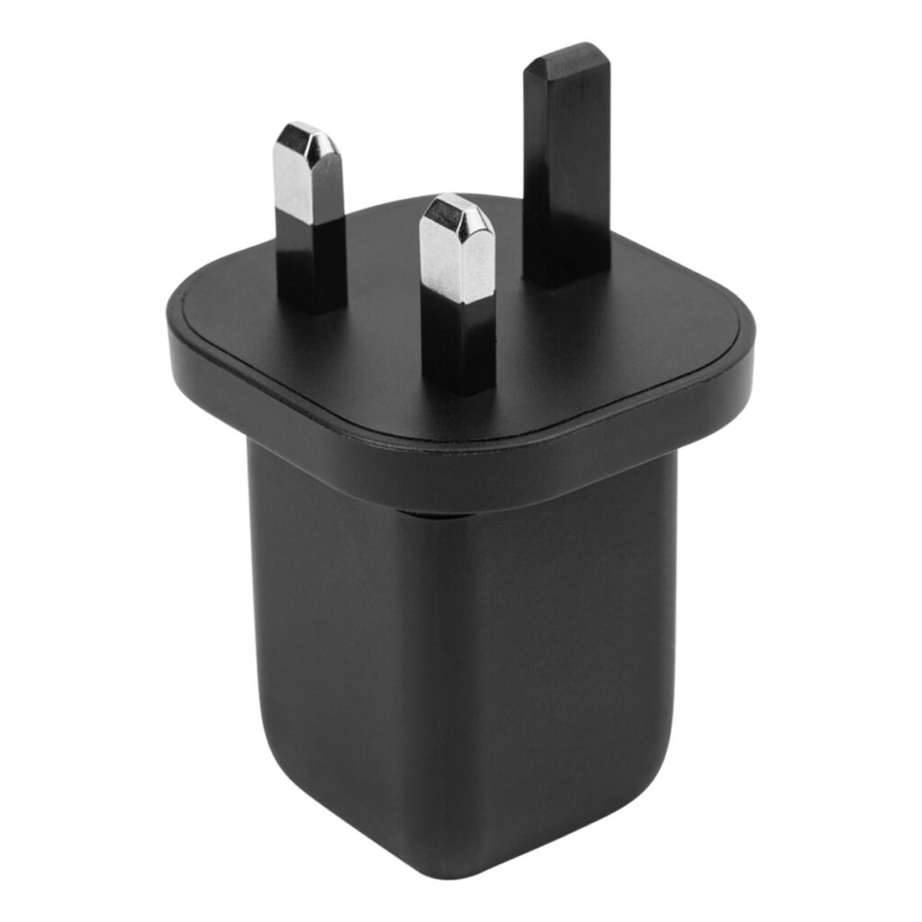 Peak-Design-Mobile-Wall-Power-Adapter-UK-1 Peak Design Mobile Wall Power Adapter UK, jossa on musta suorakulmainen pohja ja kolme metallista UK-pistoketta, kuvattuna valkoisella taustalla.