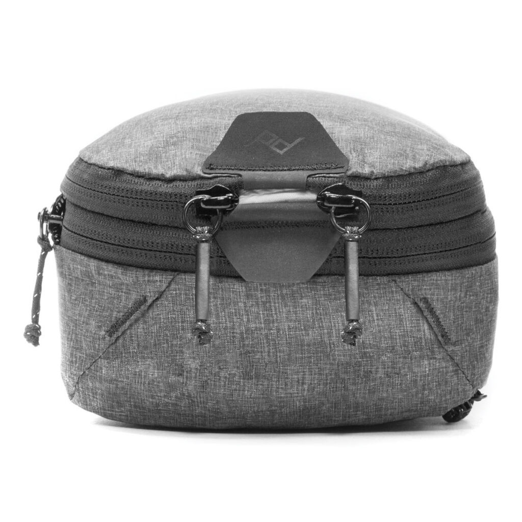 Peak-Design-Packing-Cube-Small---Charcoal2 Peak Design Packing Cube Small in Charcoal on kompakti, minimalistinen matkapussi, jossa on kaksi vetoketjun vetoketjua ja hienovarainen geometrinen kuvio, ihanteellinen lisävarusteiden tai kameravarusteiden kuljettamiseen. Sen pyöristetty muoto ja tyylikäs muotoilu sopivat järjestäytyneille matkailijoille.