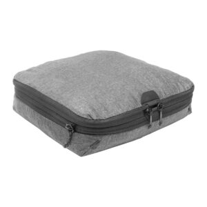 Peak-Design-Packing-Cube-medium--Charcoal1 Peak Design Packing Cube Medium in Charcoal on harmaa, suorakulmainen pakkauskuutio, jossa on kankainen rakenne, kaksinkertainen vetoketju ja hienovarainen tuotemerkki yhdessä kulmassa valkoista taustaa vasten.
