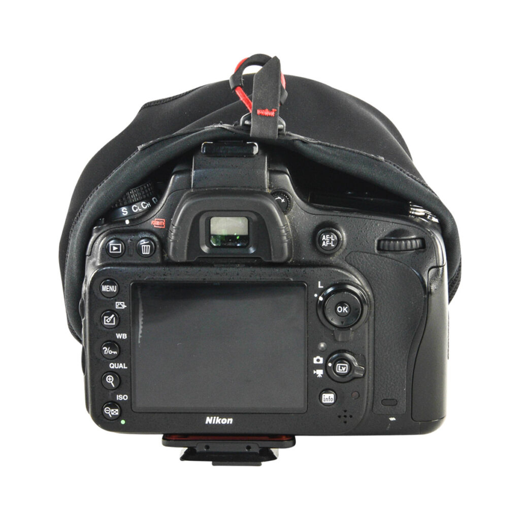 Peak-Design-Shell-3 Nikon DSLR -kameran takakuva, jossa Peak Design Shell Suojakuori Kameralle - Pieni sadesuoja on osittain vedetty päälle, ja jossa näkyvät painikkeet, valitsimet, LCD-näyttö ja etsin.