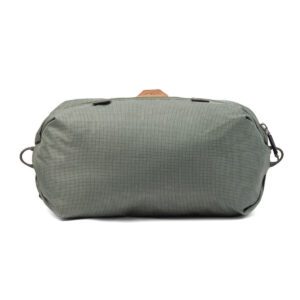 Peak-Design-Shoe-Pouch---Sage1 Peak Design Shoe Pouch in Sage on suorakulmainen matkalaukku, jossa on kuvioitu kangas, musta vetoketju ja sivulenkit, kuvassa valkoista taustaa vasten.