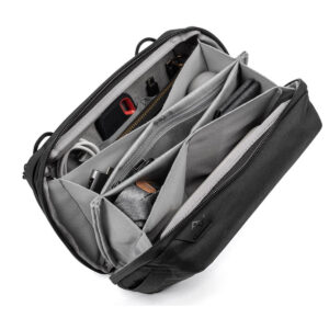 Peak-Design-Tech-Pouch-Black-2 Peak Design Tech Pouch - Black on musta ja harmaa organisointilaite, jossa on useita lokeroita, joihin mahtuu siististi kaapeleita, kyniä, vetoketjullinen pussi ja elektronisia tarvikkeita. Avoimesta pussista näkyy kaikki sen järjestetty sisältö.