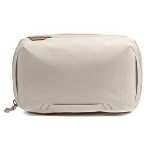 Peak-Design-Tech-Pouch-Bone-1 Peak Design Tech Pouch - Bone on beige, suorakaiteen muotoinen matkapussi, jossa on vetoketju ja pieni nahkainen korostus yläkulman lähellä valkoista taustaa vasten.