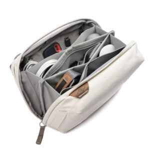 Peak-Design-Tech-Pouch-Bone-2 Peak Design Tech Pouch - Bone on beige vetoketjullinen pussi, jossa on useita lokeroita, joissa kaapelit, hiiri, laturi ja pienet vempaimet pysyvät siististi järjestyksessä.