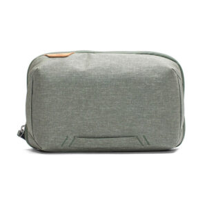 Peak-Design-Tech-Pouch-Sage-1 Peak Design Tech Pouch in Sage on suorakulmainen, vaaleanharmaanvihreä matkapussi, jossa on minimalistinen muotoilu, vasemmanpuoleinen vetoketju ja hienovaraiset tikkaukset edessä.