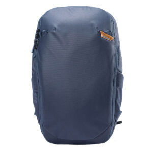Peak-Design-Travel-Backpack-30L-midnight2 Peak Design Travel Backpack 30L -kamerareppu, tummansininen on tyylikäs, tummansininen reppu, jossa on sileä etuosa, sivutaskut, vetoketju ylhäällä vasemmalla ja pieni ruskea logolaastari oikeassa yläkulmassa. Kuvattu pystyasennossa valkoista taustaa vasten.