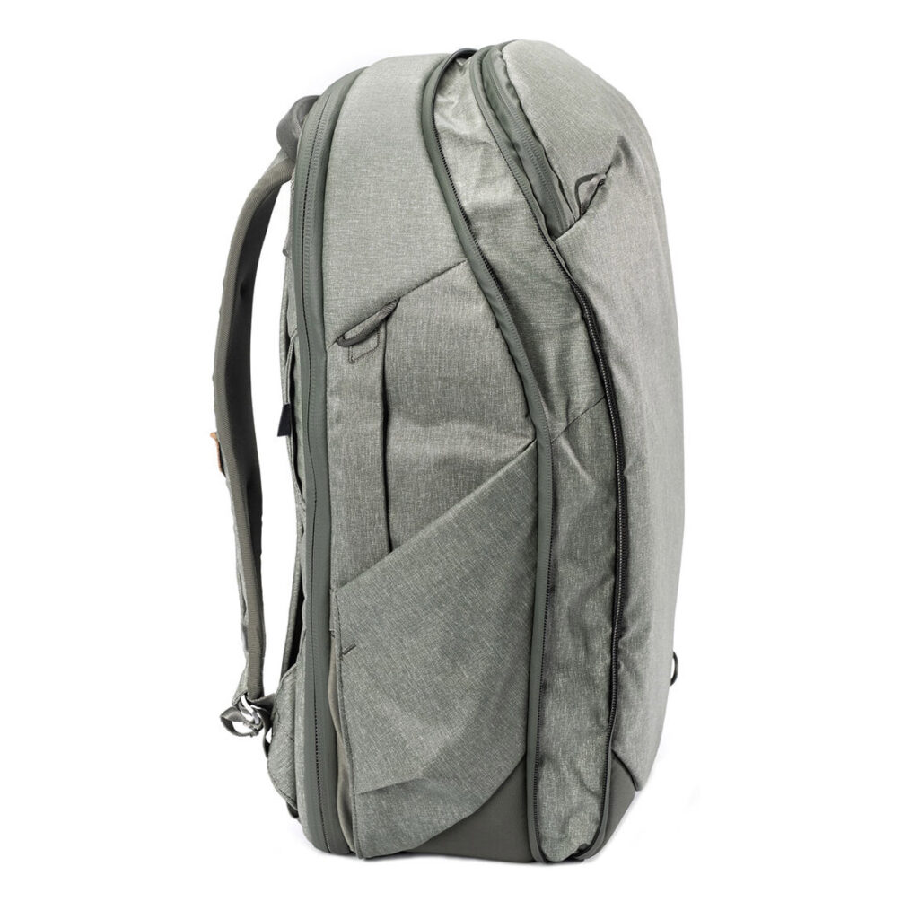 Peak-Design-Travel-Backpack-30L-sage3 Peak Design Travel Backpack 30L -kamerareppu, vaaleanvihreä seisoo pystyssä sivukuvassa, ja siinä on useita lokeroita, vetoketjut, säädettävät hihnat, kaksi ulkoista sivutaskua ja kestävä vedenkestävä kangas.