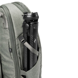 Peak-Design-Travel-Backpack-30L-sage6 Vaaleanvihreä Peak Design Travel Backpack 30L -reppu, jonka sivutaskussa on musta hiilikuituinen jalusta, joka korostaa vetoketjua ja kankaan rakennetta.