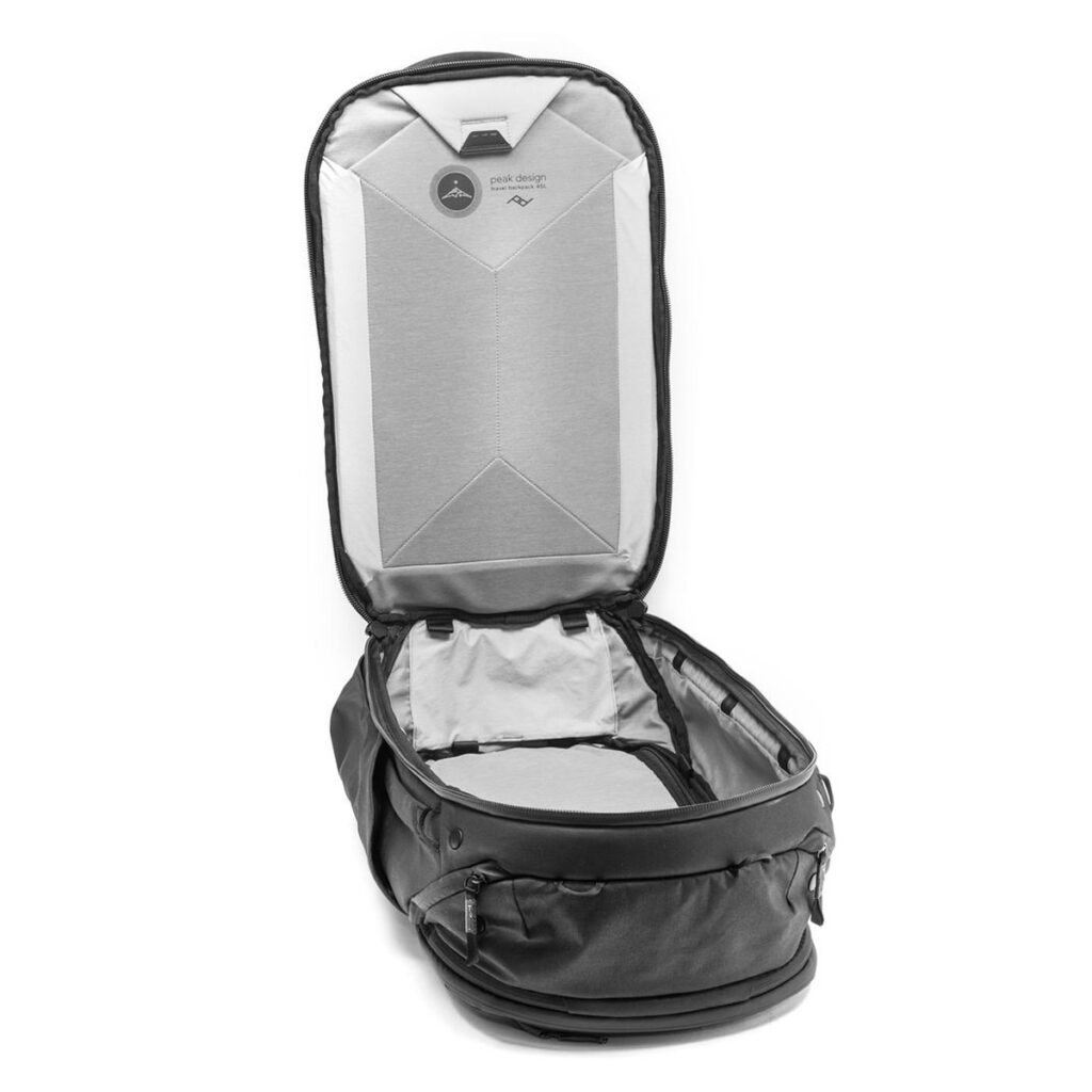Peak-Design-Travel-Backpack-45L-black03 Peak Design Travel Backpack 45L -kamerareppu, musta näkyy selällään avattuna ja tyhjänä, jolloin paljastuu tilava päälokero, jonka kannessa on verkkovetoketjullinen verkkotasku ja harmaa sisävuori.