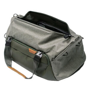 Peak-Design-Travel-Duffel-35l-sage-2 Peak Design Travel Duffel 35L - Sage on tilava ja toiminnallinen vihreä ja harmaa laukku, jossa on mustat vetoketjut ja kahvat, avoin päälokero, etutasku ja nahkakoristeinen kahva.