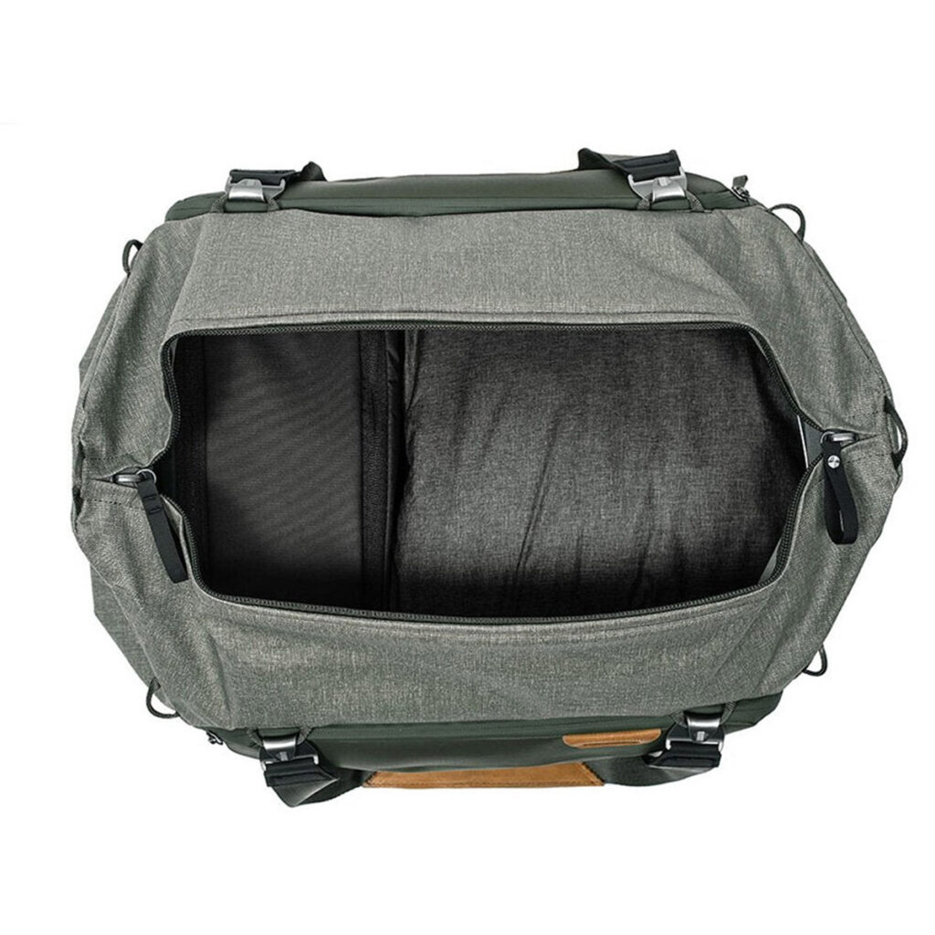 Peak-Design-Travel-Duffel-35l-sage-3 Ylhäältä alas näkymä avoimesta, tyhjästä Peak Design Travel Duffel 35L - Sage -laukusta, jossa on mustat hihnat ja vetoketjut ja jossa korostuvat sen tilava päälokero ja sisäiset jakajat.