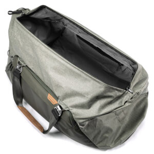 Peak-Design-Travel-Duffel-65l-sage-2 Peak Design Travel Duffel 65L - Sage on tilava, avoin harmaan ja vihreän värinen laukku, jossa on mustat hihnat, ruskea nahkakahva-aksentti ja tyhjä päälokero kuvattuna ylhäältä katsottuna.