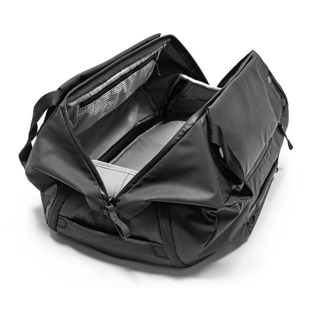 Peak-Design-Travel-Duffelpack-65l-black-03 Peak Design Travel Duffelpack 65L mustassa kuvassa päälokero on avattu, ja siinä on tilavat sisätaskut ja verkko-organisaattorit valkoista taustaa vasten.