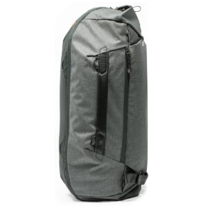 Peak-Design-Travel-Duffelpack-65l-sage-3 Peak Design Travel Duffelpack 65L Sage -mallistossa on tyylikäs ja moderni muotoilu mustilla vetoketjuilla ja kahvoilla, useilla lokeroilla ja tukevalla kankaalla. Kuvattu pystyasennossa valkoista taustaa vasten.