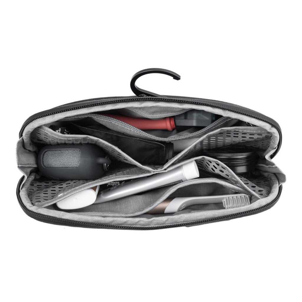 Peak-Design-Wash-Pouch-Small-Black3 Ylhäältä katsottuna avoin Peak Design Wash Pouch Small - Black, jossa on lokeroita, joihin mahtuu sähköhammasharja, partakone, kynsisakset ja paljon muuta. Yläosassa näkyy koukku ripustamista varten.