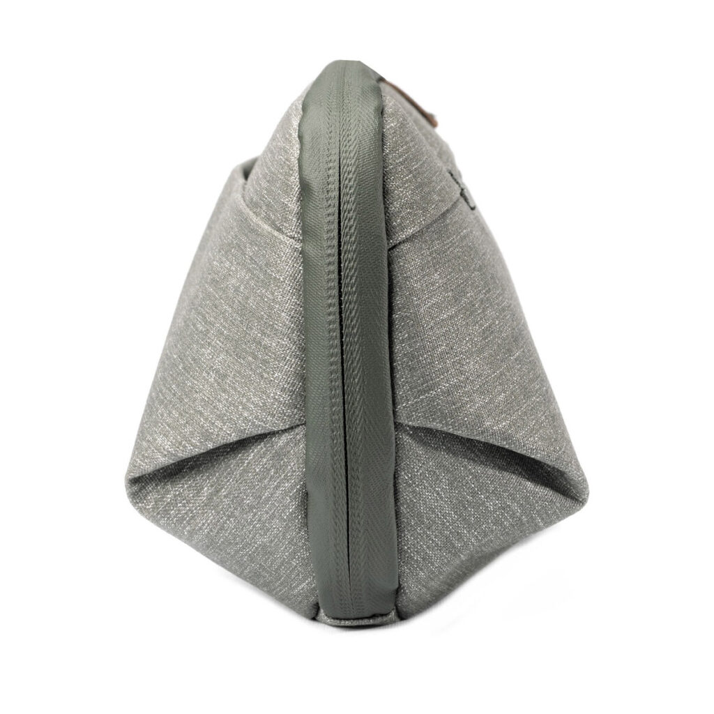 Peak-Design-Wash-Pouch-Small-Sage4 Sivukuva Peak Design Wash Pouch Small in Sage -pesupussista, jossa on harmaa kangas, vihreä vetoketju ja reunus, pystyasennossa valkoista taustaa vasten.