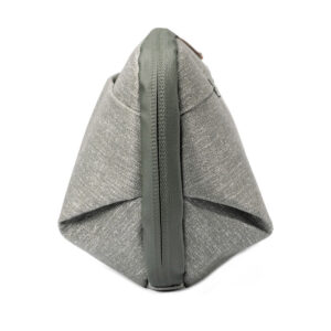 Peak-Design-Wash-Pouch-Small-Sage4 Sivukuva Peak Design Wash Pouch Small in Sage -pesupussista, jossa on harmaa kangas, vihreä vetoketju ja reunus, pystyasennossa valkoista taustaa vasten.