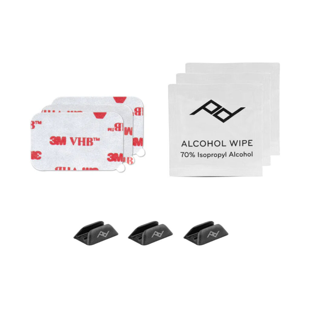 Peak-Design-spareparts-adhesive-pads-car-mount-1 Peak Design Spareparts - Mobile Car Mount VHB Pad Set sisältää kolme mustaa kaapelikiinnikettä, joissa on minimalistinen logo, kaksi punaista 3M VHB -liimatyynyä ja kolme Alcohol Wipe 70 % Isopropyl Alcohol -pakettia valkoisella pohjalla.