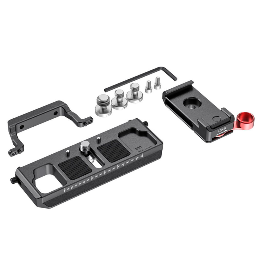 SmallRig 2403 Offset Kit BMPCC 4K/6K:lle ja Ronin S:lle sisältää metallisen pohjalevyn, jossa on merkinnät, L-muotoisen kiinnikkeen, punaisella vivulla varustetun pikakiinnikkeen, ruuvit ja kuusiokoloavaimen - kaikki siististi järjestetty valkoiselle pohjalle.