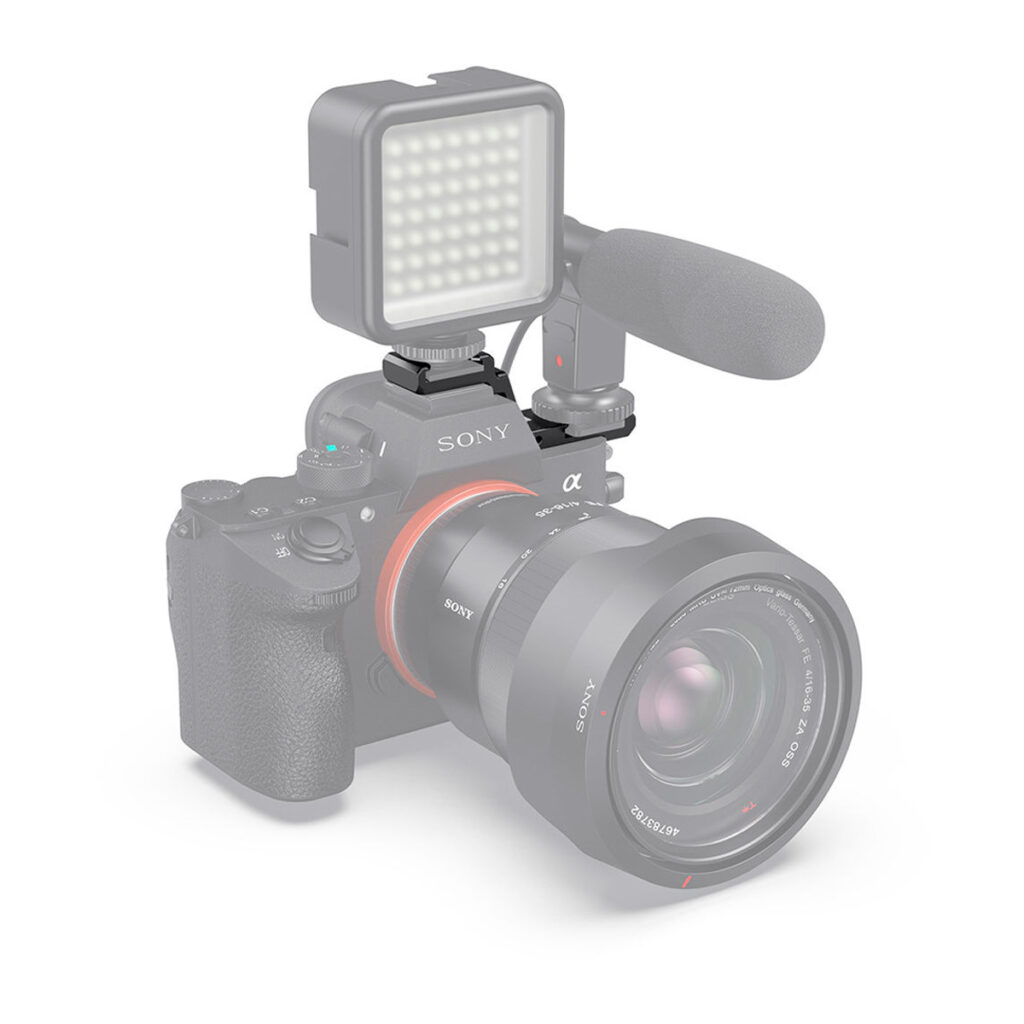 SmallRig-2662-5 SmallRig 2662 Cold Shoe Extension Plate for Sony A7III/A7RIII -laajennuslevy Sony A7III/A7RIII on kuvassa asennettuna digitaalikameraan, jossa on suuri objektiivi, ulkoinen mikrofoni ja suorakulmainen LED-valo valkoista taustaa vasten.