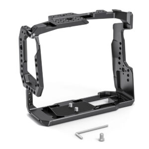 SmallRig-2765-5 SmallRig 2765 Cage for BMPCC 4K/6K with Battery Grip on musta metallinen, avoin suorakulmainen häkki, jossa on useita kiinnitysreikiä, kaksi ruuvia ja L-muotoinen kuusiokoloavain. Siinä on tukeva kulmikas muotoilu, ja se näkyy valkoisella pohjalla.