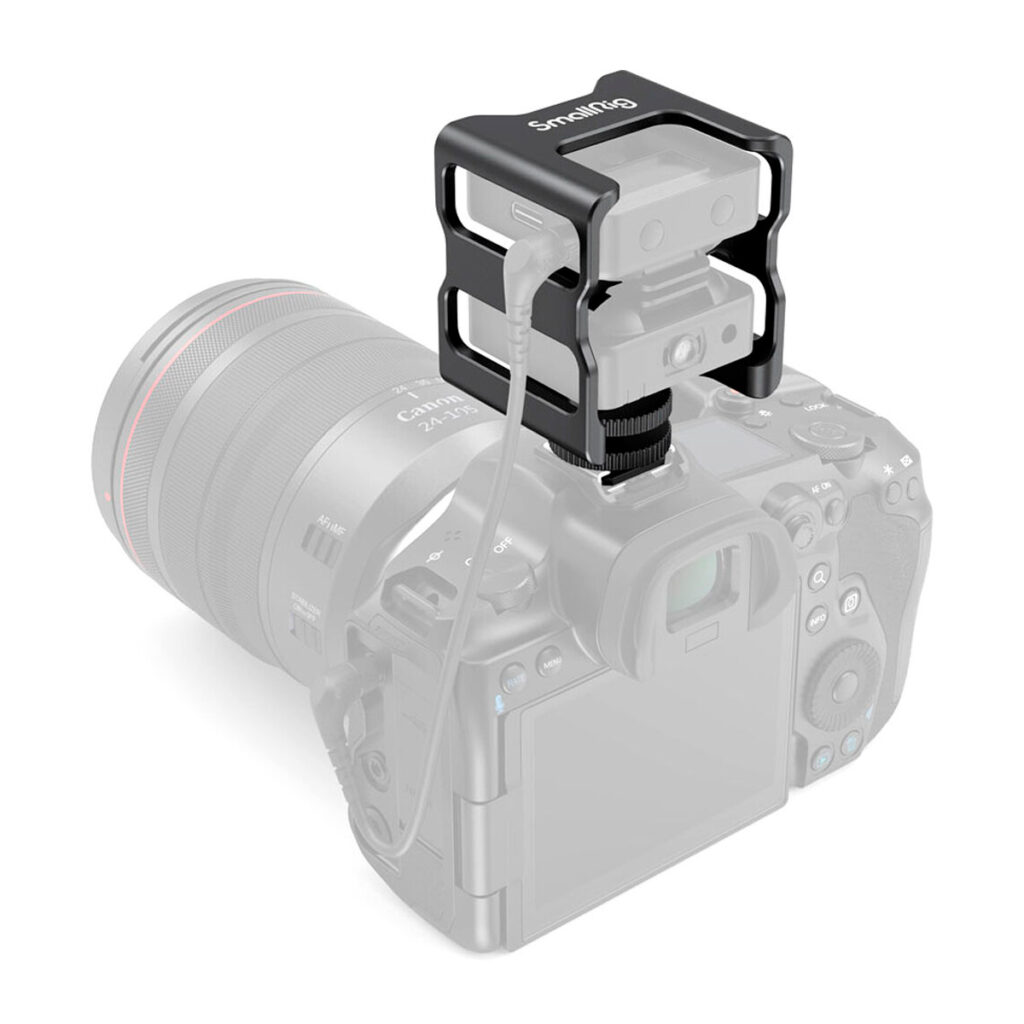 SmallRig-2998-4 SmallRig 2998 Cage for Rode Wireless Go, kuvassa mustaa metallia ja kaapelilla kytketty, on asennettu harmaan DSLR-kameran ja objektiivin päälle korostamaan lisävarustetta.