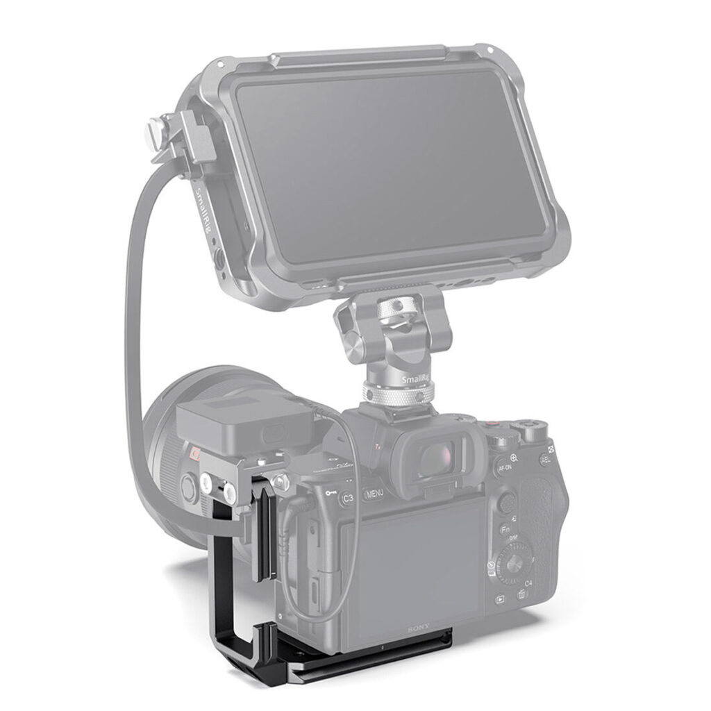 SmallRig-3003-5 Sony A7S III, jonka päälle on kiinnitetty digitaalinen monitori tukevalla kaapelilla, ja joka on tuettu mustalla SmallRig 3003 L-telineellä valkoista taustaa vasten.