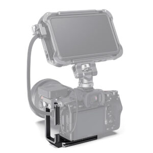 SmallRig-3003-5 Sony A7S III, jonka päälle on kiinnitetty digitaalinen monitori tukevalla kaapelilla, ja joka on tuettu mustalla SmallRig 3003 L-telineellä valkoista taustaa vasten.