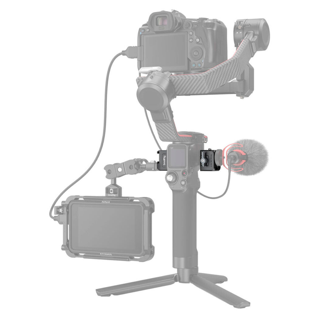 SmallRig-3025-3 Kuvassa on jalustalla oleva kamerarigi, jossa käytetään SmallRig 3025 Mounting Plate for DJI Ronin RS 2 / RSC 2 / RS 3 / RS 3 Pro / RS 3 mini -kiinnityslevyä DJI Ronin RS 2 / RSC 2 / RS 3 / RS 3 Pro / RS 3 mini, jossa kamera, mikrofoni, monitori ja gimbaali on liitetty kiinnitysvarsilla ja kaapeleilla vaaleanharmaalla ääriviivalla.