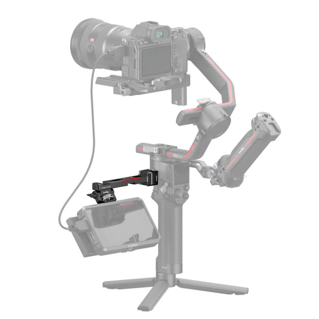 SmallRig-3026B-2 The picture shows a professional camera with a handheld gimbal and tripod on which an external monitor is mounted using the SmallRig 3026B Monitor Mount for DJI Ronin. Some parts of the mount appear semi-transparent grey.