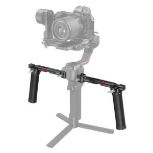 SmallRig-3027 Kamera asennettuna SmallRig 3027 Dual Handgrip for DJI RS2/RSC2/RS3/RS3/RS3 Pro -käsikahvaan, jossa on kaksi sivukahvaa ja pieni jalustan jalusta, valkoista taustaa vasten.
