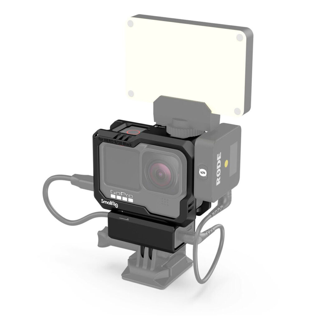 SmallRig-3083-4 GoPro-kamera SmallRig 3083 Cage for GoPro HERO 9 / HERO 10 -kamerahäkissä, jossa on kaapelit, Rode-mikrofoni ja suorakaiteen muotoinen LED-valopaneeli asennettuna päälle, kaikki valkoista taustaa vasten.