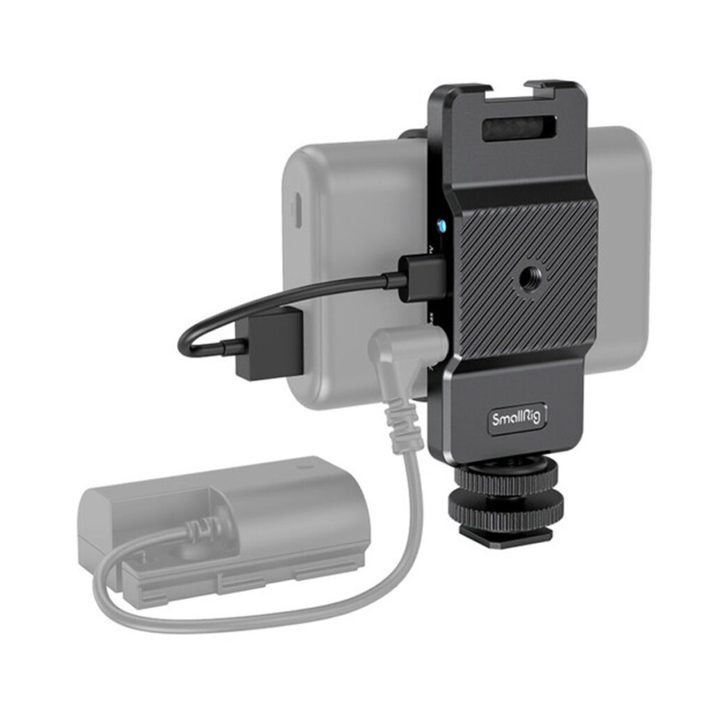 SmallRig-3085-4 Älypuhelin on asennettu mustaan SmallRig 3085 Powerbank -sovittimeen, johon on liitetty ulkoinen akku kaapeleilla, mikä havainnollistaa kannettavaa videotallennus- tai latausasennusta. Akku ja kaapelit on korostuksen vuoksi osittain harmaasävytetty.