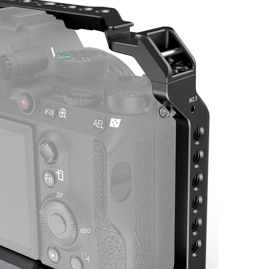 SmallRig-3133-3 Lähikuva SmallRig 3133 Cage & Sidehandle Kit for Sony A7 III/A7R III/A9 -laitteelle, joka sulkee kameran osittain mustaan metallihäkkiin, jossa on useita kiinnitysreikiä ja M2,5-merkintä, ja tarjoaa suojaa ja lisävarusteiden kiinnitysmahdollisuuksia.