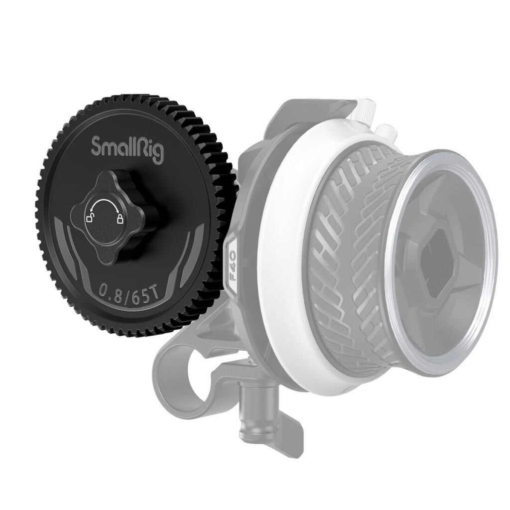 SmallRig-3200-2 SmallRig 3200 Gear 0.8-65T for Mini Follow Focus -vaihde, musta, jossa on hampaat ja keskimmäinen nuppi, on kuvassa kameran objektiiviin kiinnitetyn puoliksi läpinäkyvän follow focus -järjestelmän edessä.