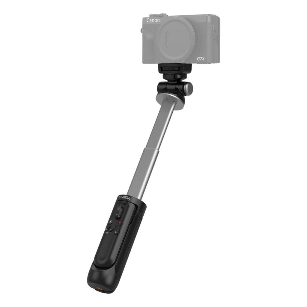 SmallRig-3326-2 SmallRig 3326 SR-RG1 Wireless Shooting Grip mustaa ja hopeaa, joka on kuvassa laajennettuna käsikäyttöisenä selfie stick -jalustana kaukosäätimellä, pitää puoliksi läpinäkyvää Canon G7X -digitaalikameraa.