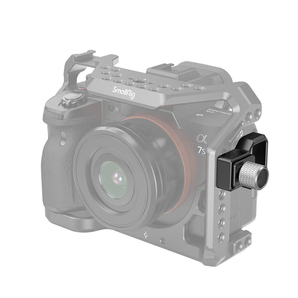 SmallRig-3421-2 Mustan ja hopeanvärinen objektiivisovitin kiinnitetään Sony A7S III:n oikeaan kylkeen SmallRig 3421 Professional Kit -laitteen avulla. Kamera ja rig näkyvät harmaina, kun taas sovitin erottuu värillisenä korostuksen vuoksi.