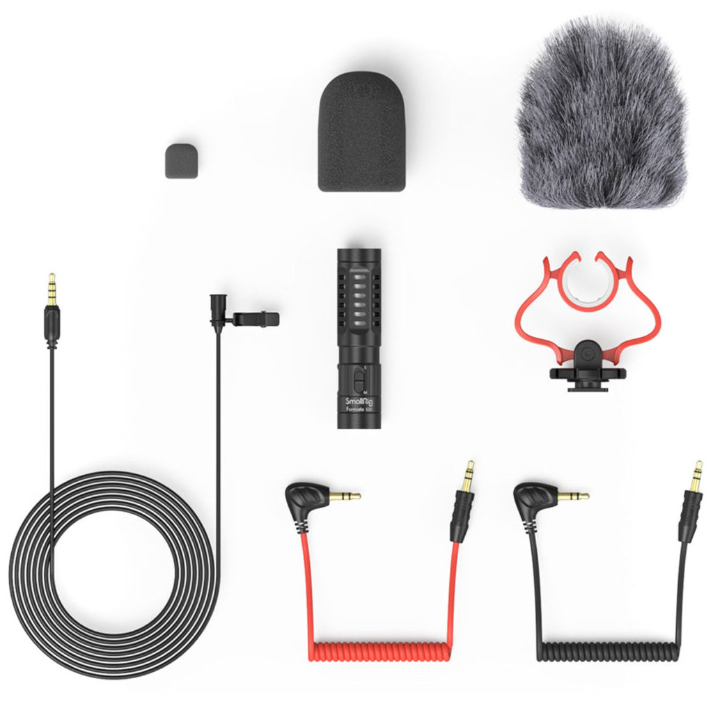 SmallRig-3468-3 SmallRig 3468 Forevala S20 On-Camera Microphone -mikrofonipakkaus, jossa mikrofoni, vaahtomuoviset ja karvaiset tuulisuojat, sylimikrofoni, kaapelit, iskunvaimennin ja adapterit on järjestetty siististi valkoiselle taustalle.