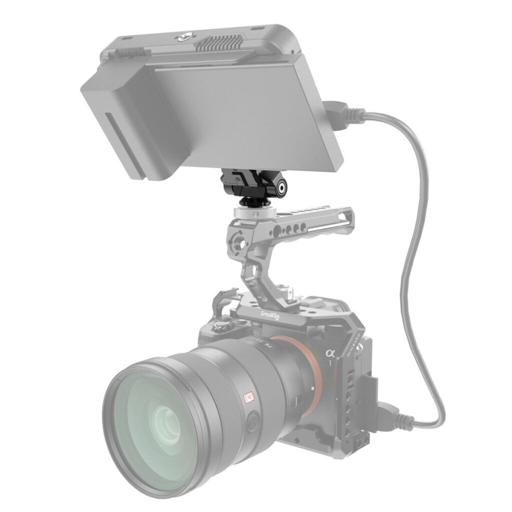 SmallRig-3514-2 Harmaa digitaalikamera harmaassa suojahäkissä käyttää SmallRig 3514 Drop-In Hawklock Mini Quick Release Monitor Mount with Cold Shoe -kiinnikettä mustan monitorin kiinnittämiseen päälle, joka on liitetty kaapelilla.