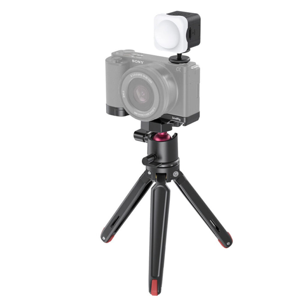 SmallRig-3525-1 SmallRig 3525 Vlogger Kit for Sony ZV-E10, kompakti musta kolmijalka punaisilla korostuksilla, tukee pientä digitaalikameraa ja kuution muotoista LED-valoa, joka on esillä tavallisella valkoisella pohjalla.