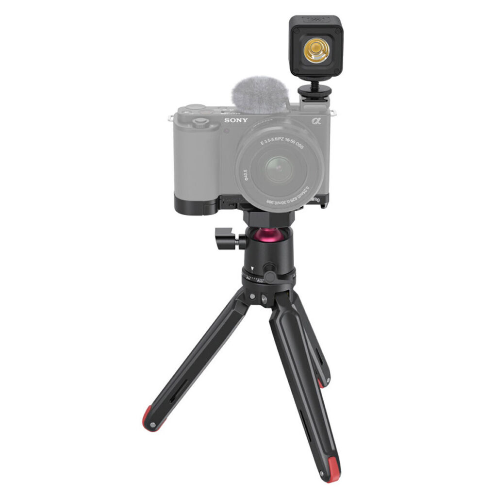SmallRig-3525-2 SmallRig 3525 Vlogger Kit for Sony ZV-E10, jossa on mikrofonilla varustettu digitaalikamera ja pieni LED-valo pienikokoisella jalustalla, jossa on punaiset korostukset, on esillä valkoista taustaa vasten.