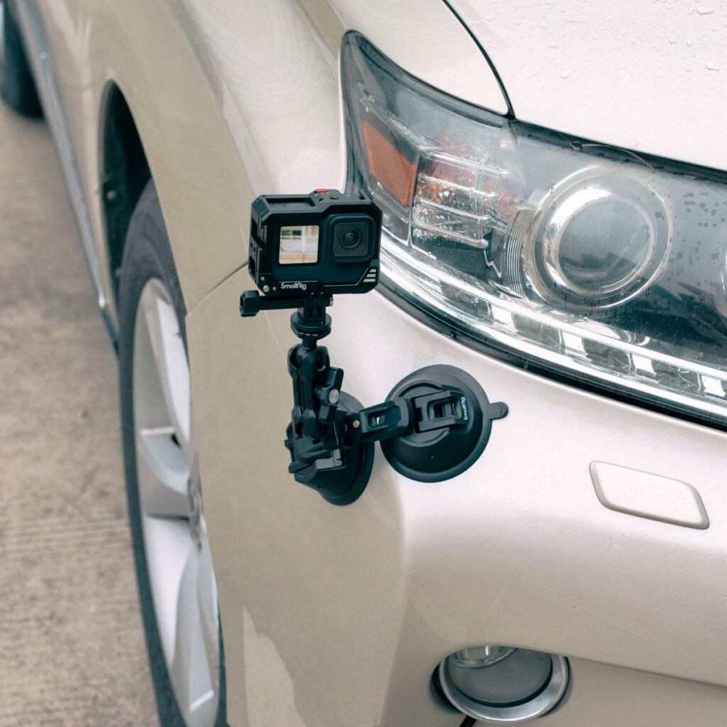 SmallRig-3566-5 SmallRig 3566 Portable Dual Suction Cup with Camera Mount SC-2K kiinnittää GoPro-kameran etulokasuojalevyyn lähelle vaalean auton ajovaloa.