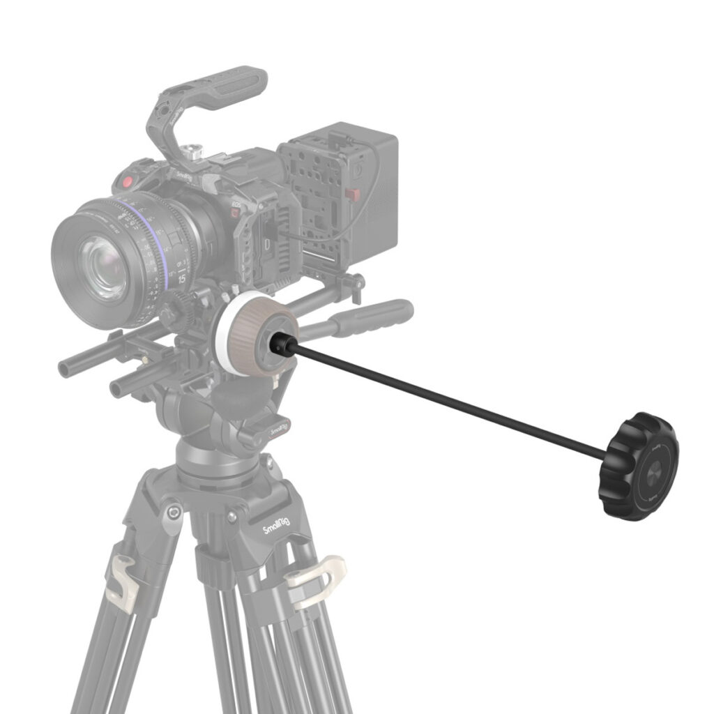 SmallRig-3851-2 SmallRig 3851 Follow Focus Whip ja nuppi näytetään yksityiskohtaisesti ammattimaisessa videokamera-asetelmassa, jossa on jalusta, kun taas muu laitteisto häivytetään pehmeästi taustalle.