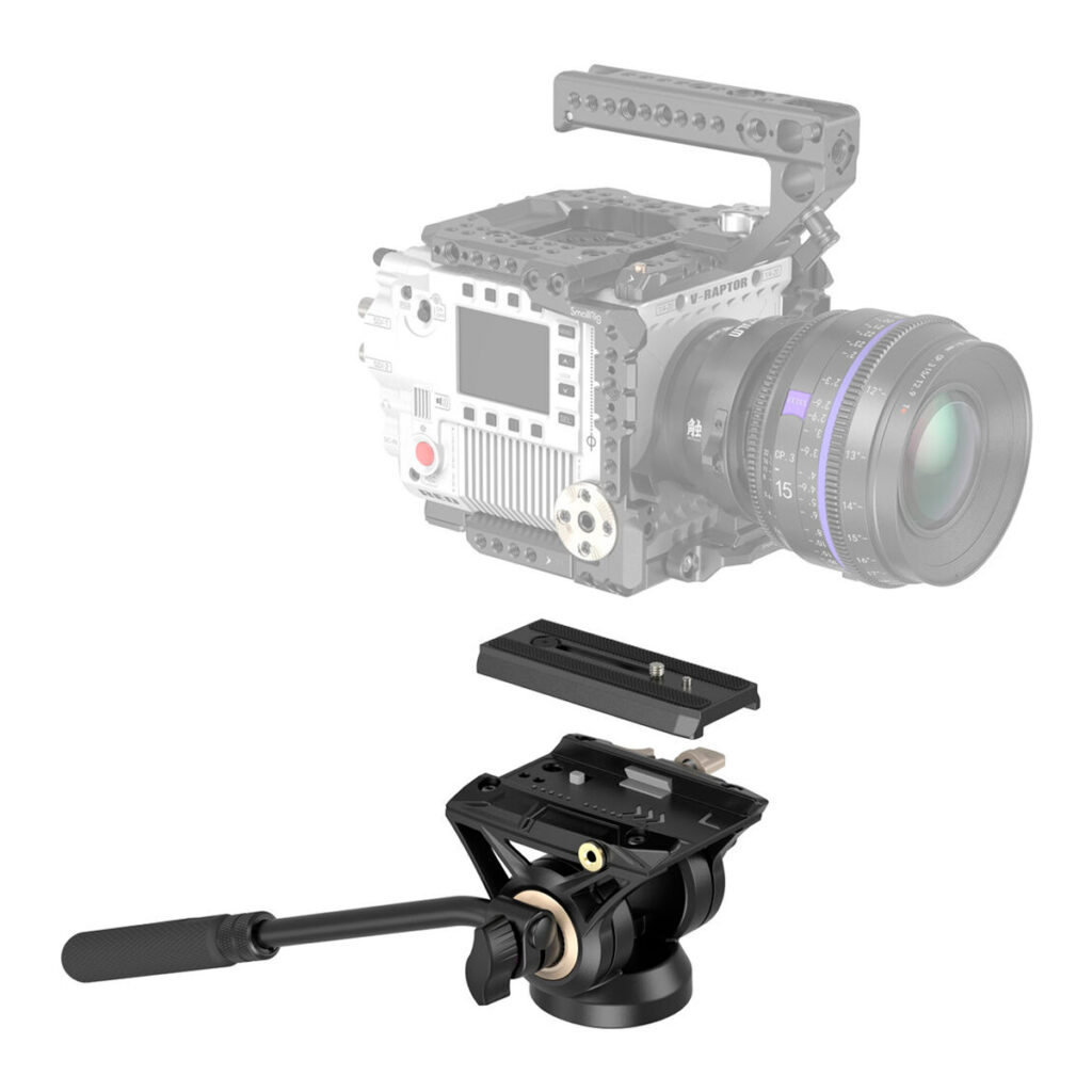 SmallRig-3985-3 Taustalla näkyy haalistunut ammattilaisvideokamera häkki ja objektiivi, kun taas edessä näkyy näkyvästi SmallRig 3985 Fluid Head DH-01 -videopää kolmijalka, jossa on pikavapautuslevy ja panorointikahva.