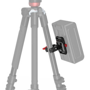 SmallRig-3989-3 SmallRig 2989 Battery Plate Mini V-Mount with Crab Clamp on kuvassa kiinnitettynä jalustan jalkaan punaisilla lukitusnupeilla, mikä korostaa akun kiinnitysjärjestelmää. Kolmijalka ja akku näkyvät osittain kuvassa.