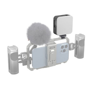 SmallRig-4055-4 Älypuhelin metallirungossa, jossa on kaksi kahvaa, harmaa pörröinen mikrofoni ja päälle asennettu SmallRig 4055 Vibe P108 Video Light RGB, jota käytetään mobiiliin videotallennukseen.
