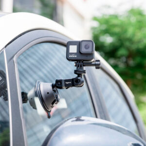 SmallRig-4193-4 SmallRig 4193 Portable Suction Cup Mount SC-1K kiinnittää toimintakameran auton ikkunaan. Taustalla näkyy sumeaa vehreyttä ja osa rakennuksesta.